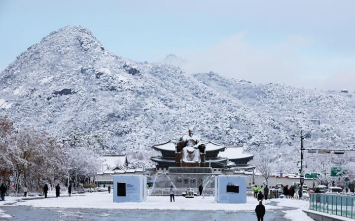 11月27日、ソウル中心部の光化門広場と北岳山が雪に覆われた。 （写真：聯合ニュース）