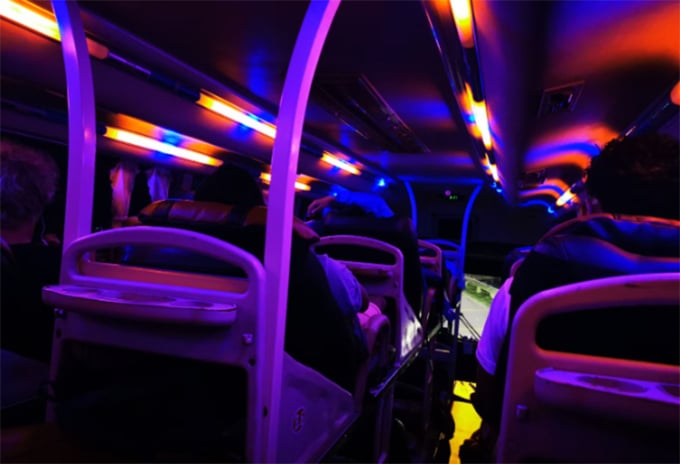 Lumières LED multicolores sur un bus-couchettes circulant la nuit au Vietnam. Photo : Aaron Spray