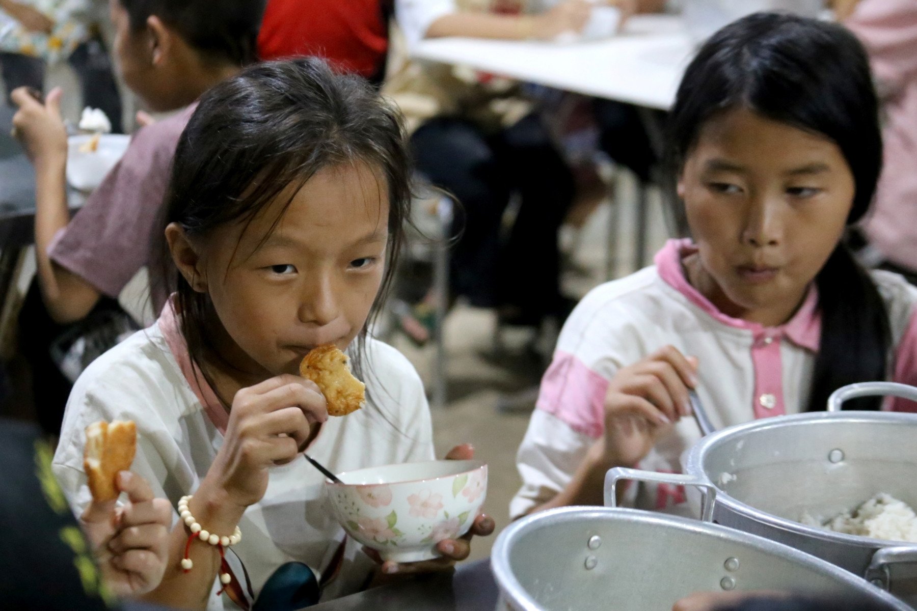 The teacher waded through the mud for 2 hours carrying potatoes and rice back to school, the teacher stayed up all night to watch over the students after the storm and flood.