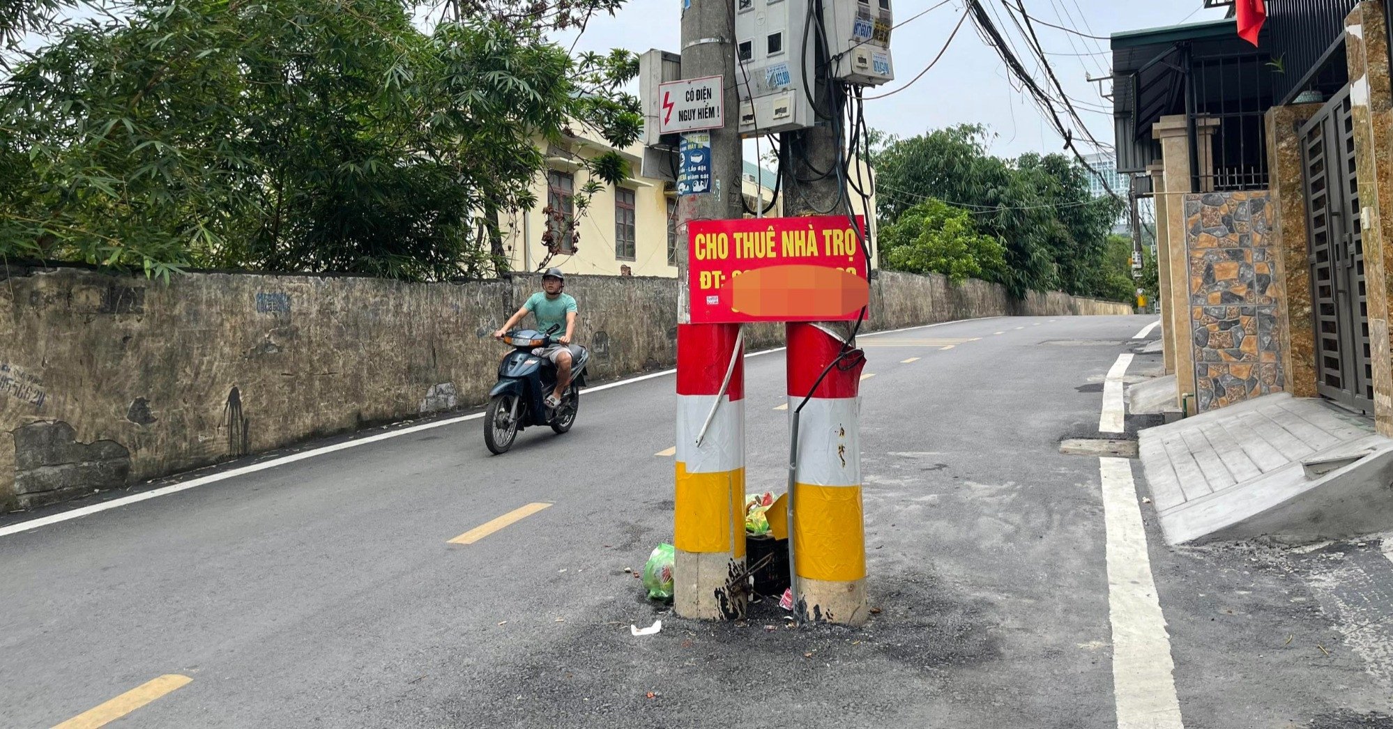 Fila de postes eléctricos bloqueando el medio de la carretera en la ciudad de Ha Long