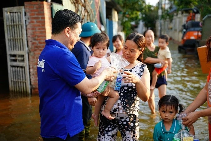 Vinamilk unterstützt Menschen in überschwemmten Gebieten am Stadtrand von Hanoi mit Milch, Wasser und vielen Geschenken. Foto 2