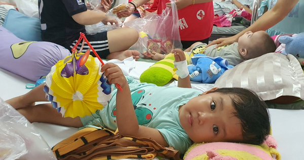 Niños sosteniendo linternas en camas de hospital...