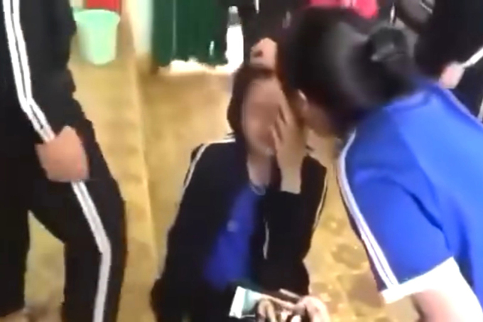 女子生徒が友人に髪の毛を引っ張られた。写真：事件を記録したビデオからの切り抜き