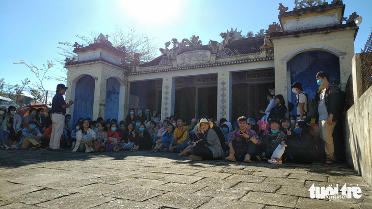 Sinh viên Đại học Sư phạm Đà Nẵng trò chuyện với người cao tuổi trước một ngôi miếu ở làng cổ Nam Ô, quận Liên Chiểu, Đà Nẵng - Ảnh: TRẦN TUẤN