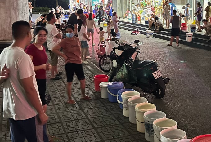 Residents of Thanh Ha Urban Area line up buckets and basins to wait for clean water on the night of October 15. Photo: Ngoc Thanh