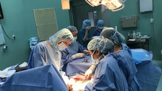 Doctors from Hung Vuong Hospital and Tam Duc Heart Hospital are performing caesarean section surgery on a pregnant woman.