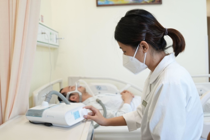 [Le docteur Phung Thi Thom ajuste l'appareil de pression positive continue CPAP pour le patient. Photo : BVCC