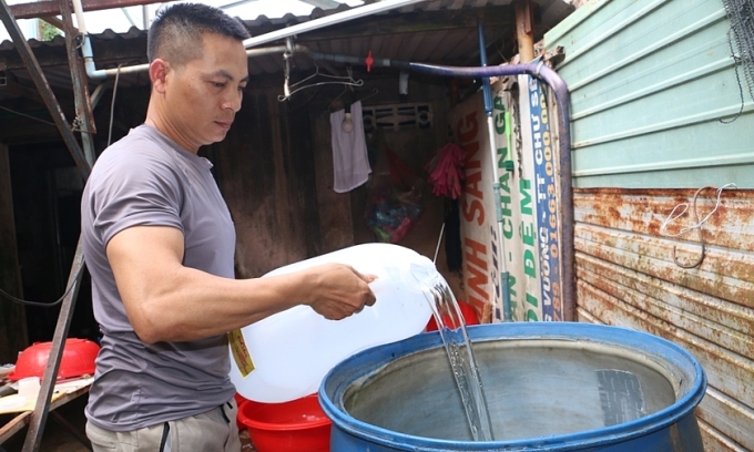 Người dân huyện Chư Sê xách từng can nước ở nơi khác về dùng. Ảnh: Quang Tấn