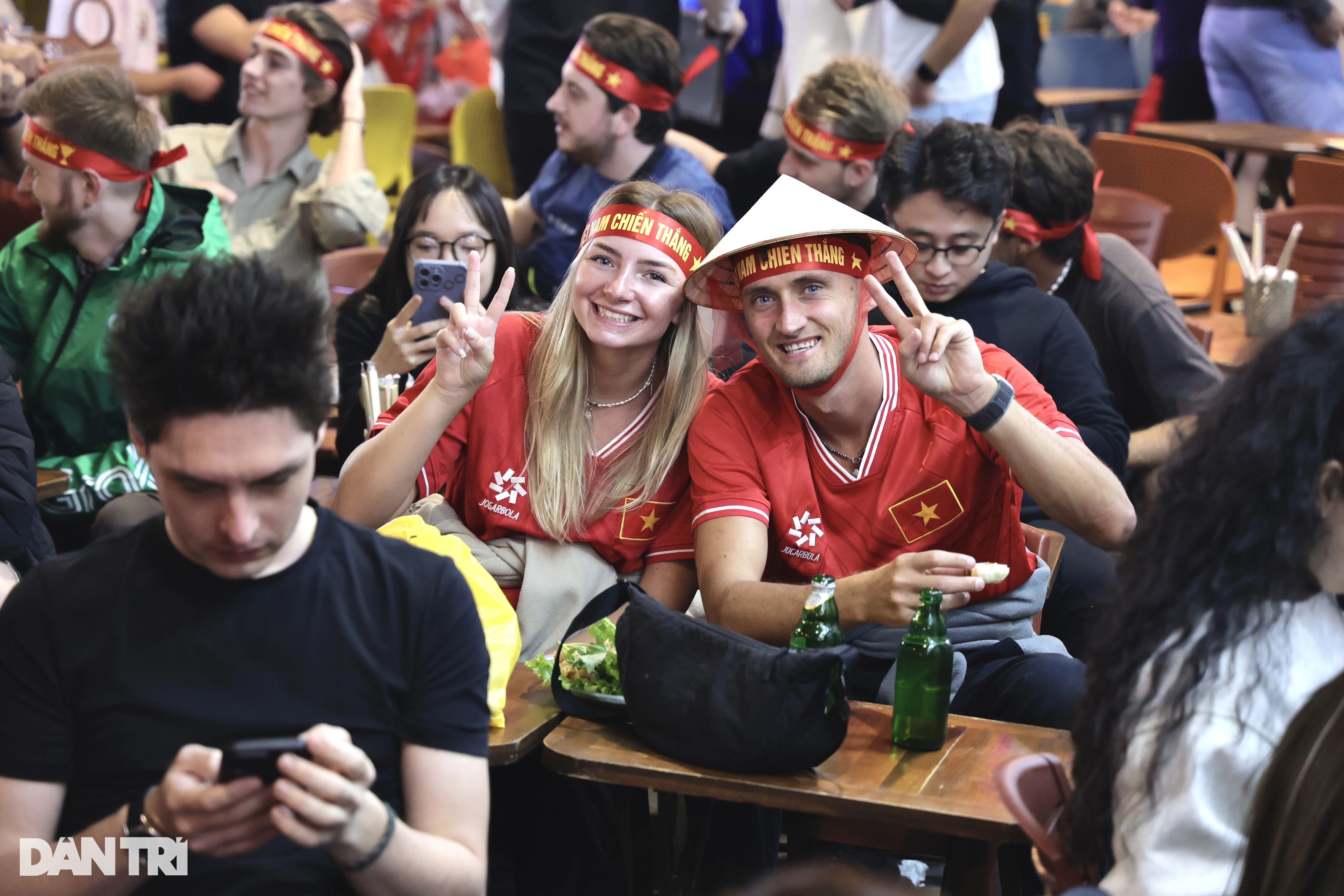 Western tourists wearing red flag shirts with yellow stars, hoarsely cheering for Vietnam