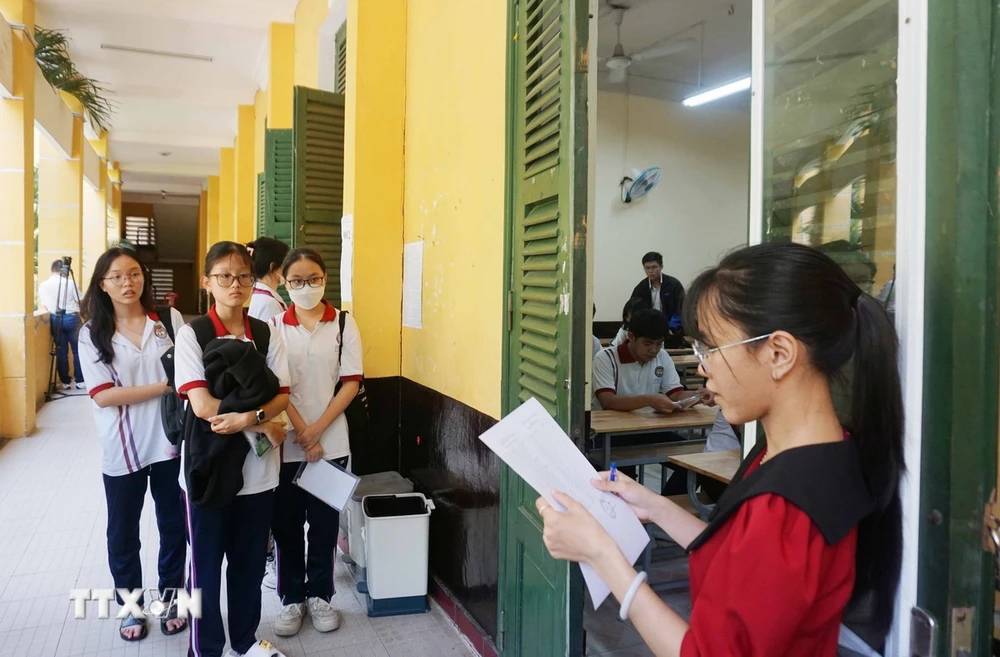 Les candidats au site d'examen du lycée Trung Vuong viennent compléter les procédures d'examen. (Photo : Thu Hoai/VNA)