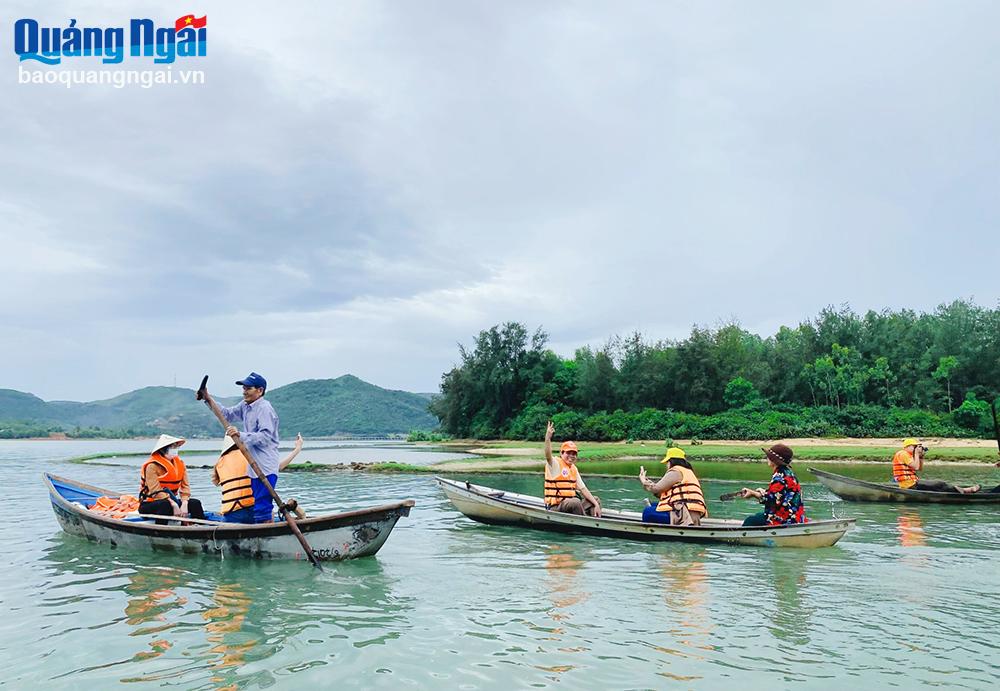 Les touristes prennent un bateau pour profiter du magnifique paysage de la lagune d'An Khe. Photo : TP