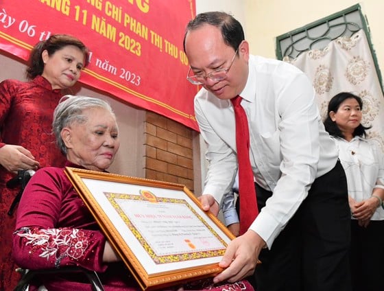 El subsecretario del Comité del Partido de Ciudad Ho Chi Minh, Nguyen Ho Hai, entregó la insignia de 75 años de membresía del Partido a la camarada Phan Thi Thu Quy. Foto: VIET DUNG