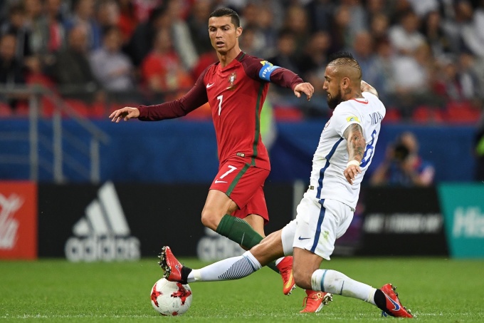 Vidal (in white shirt) tackles Ronaldo during a match between Chile and Portugal. Photo: AFP