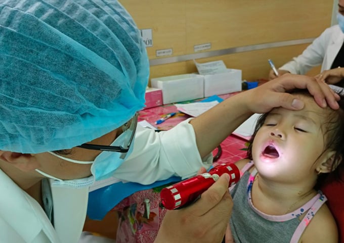 의사가 6월 16일 칸토 어린이 병원으로 이송된 손, 발, 입 질병 의심 환자를 진찰하고 있다. 사진: Huy Thanh