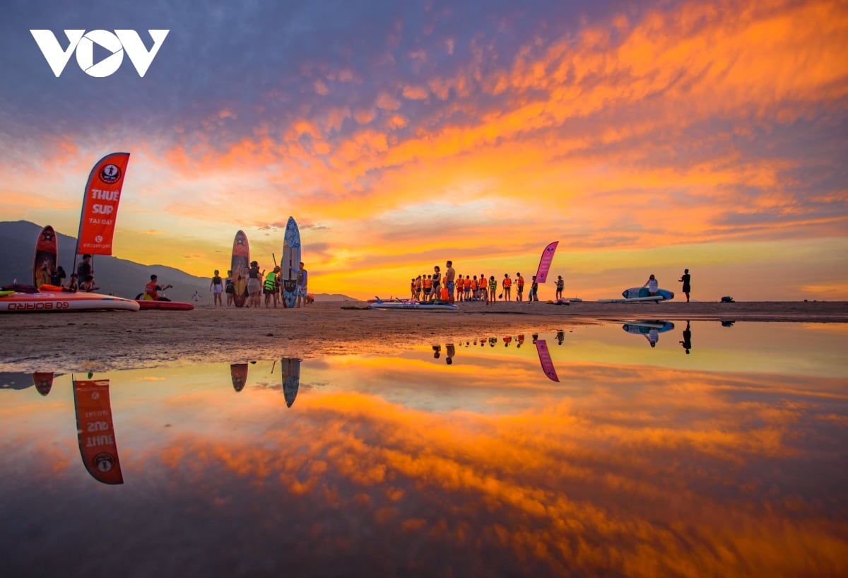 Junge Leute paddeln eifrig auf dem SUP, um den Sonnenaufgang am Strand von Da Nang zu beobachten