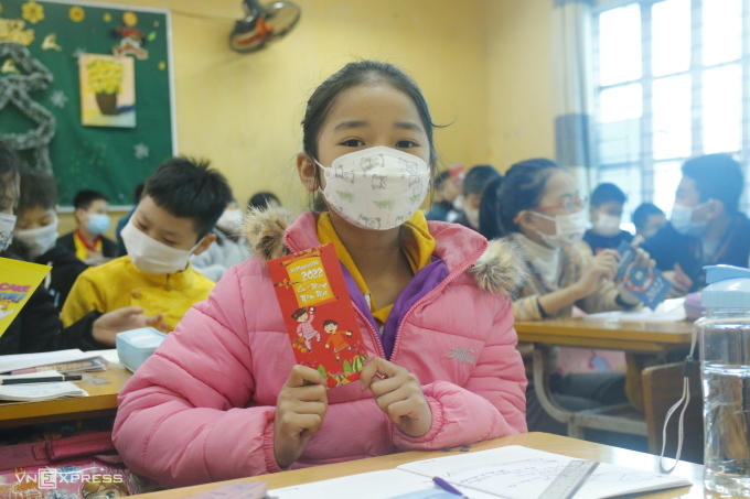 Students of class 5C, Hai Boi Primary School, Dong Anh District (Hanoi) received lucky money from their homeroom teacher and the parents' committee on the first day back to school after 9 months of online learning, February 10, 2022. Photo: Thanh Hang