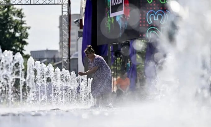 Ein russischer Bürger kühlt sich am 4. Juli unter einem Wasserhahn ab. Foto: Sefa Karacan/Anadolu Agency