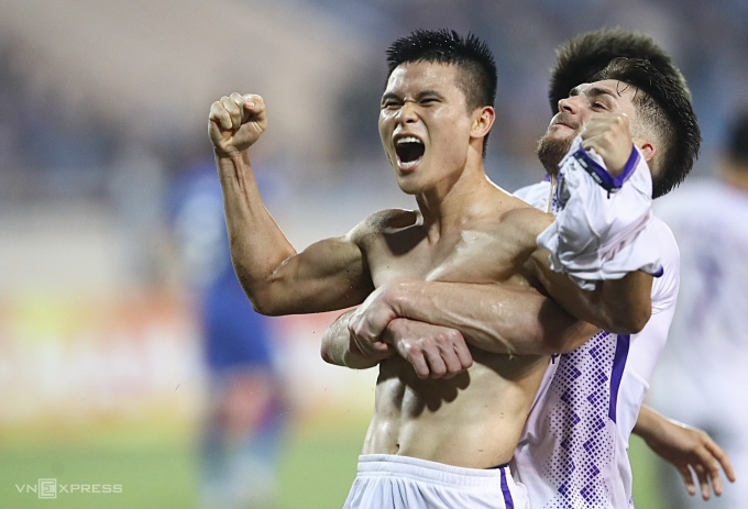 Pham Tuan Hai (left) took off his shirt to celebrate the winning goal for Hanoi FC 2-1 against Wuhan Three Towns in the 90th minute. Photo: Trung Nhu