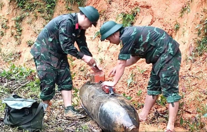 Công binh đưa quả bom lên khỏi mặt đất. Ảnh: Gia Hân