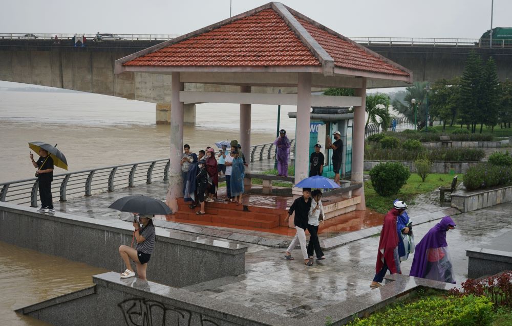 Many people gathered at Ham Rong Bridge to watch the flood and recorded videos to post on social media. Photo: Quach Du