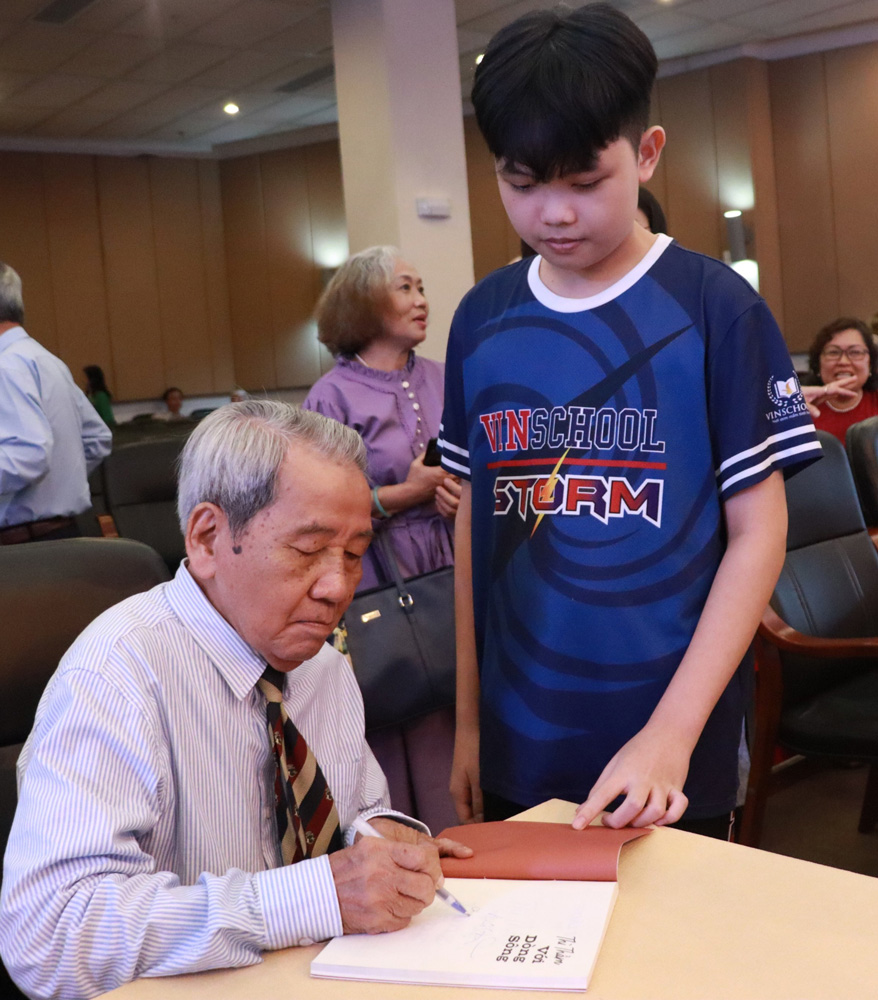 Poet Hoai Vu signs books for students
