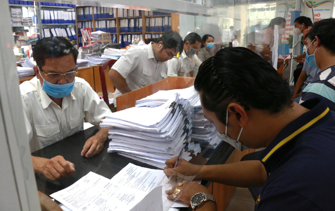 Yetkililer, Nisan 2022'de Ho Chi Minh Şehri'nin Thu Duc bölgesinde vatandaşlara idari prosedürler konusunda rehberlik ediyor. Fotoğraf: Thai Anh