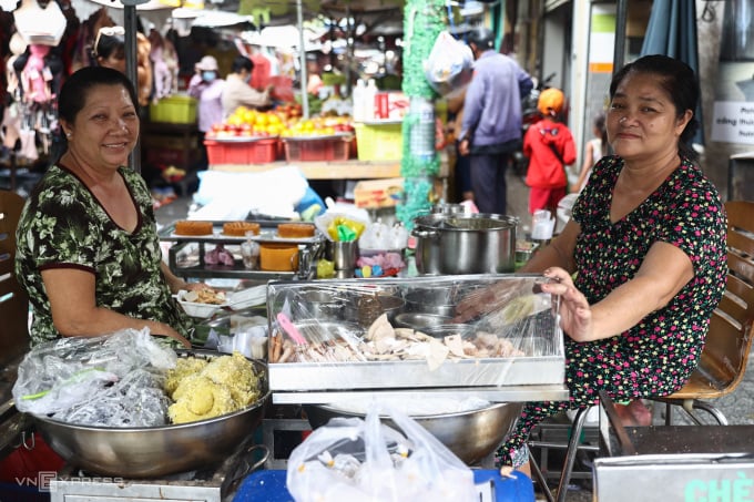 La Sra. Lan Anh (esquina izquierda) y su hermana venden arroz glutinoso en la esquina del mercado de Phung Hung. Foto: Quynh Tran