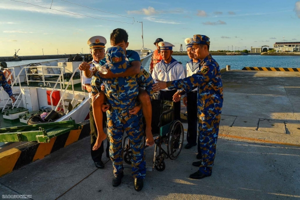 Судно 404, военно-морской регион 4, принимает рыбаков, терпящих бедствие, на острове Труонг Са для оказания медицинской помощи