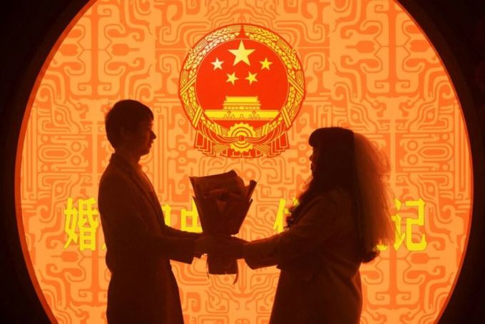 2023年2月14日、中国浙江省杭州市で、新婚カップルが婚姻届を提出した後、写真撮影に応じる。写真：チャイナデイリー