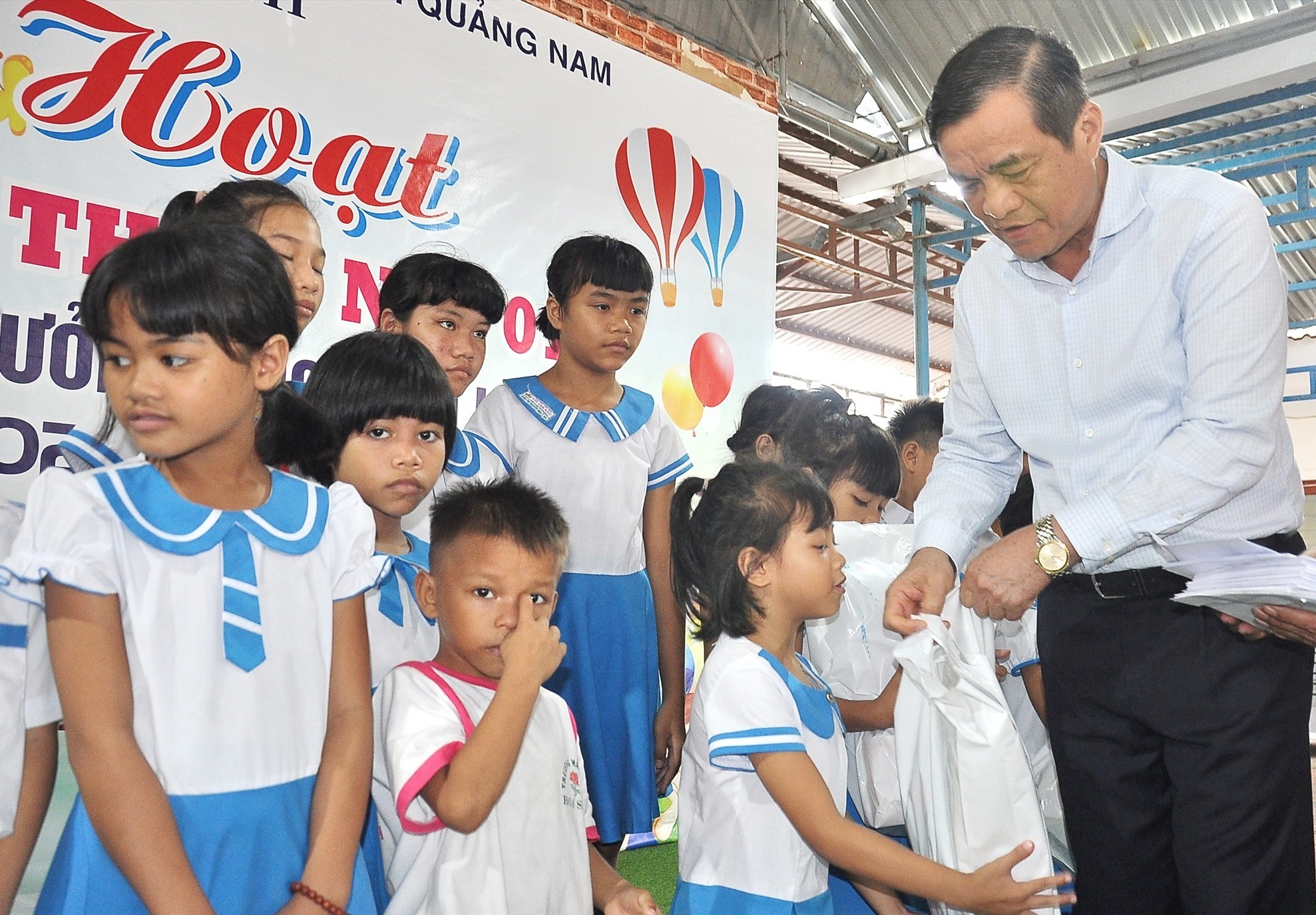 Children of Hoa Binh Village receive gifts from Provincial Party Secretary Phan Viet Cuong. Photo: V.A