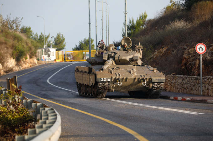 An Israeli army Merkava tank blocks one of the entrances to the northern Israeli kibbutz of Misgav Am near the border with Lebanon on October 10, 2023. AFP
