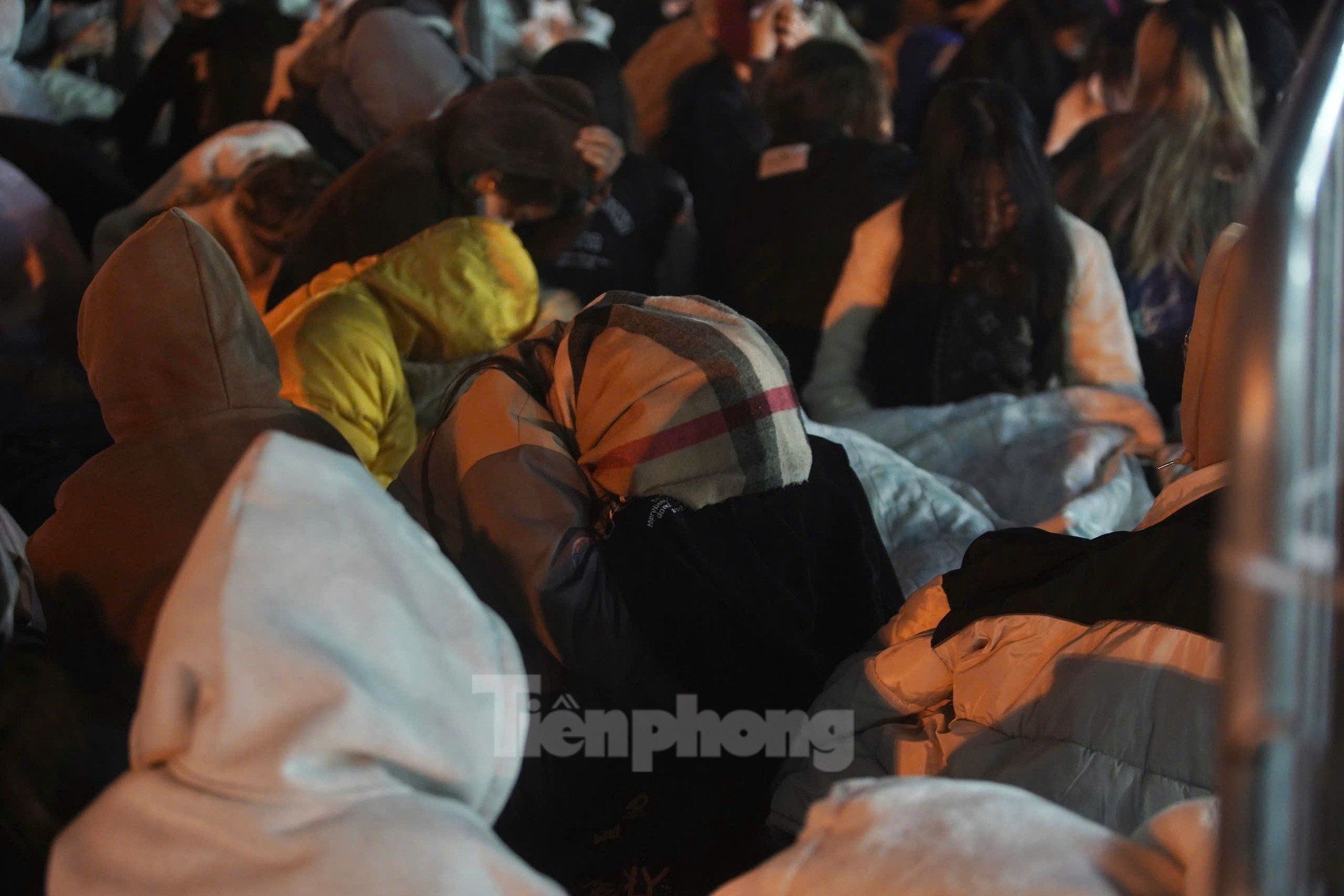 Long lines of spectators covered in scarves, sitting and sleeping right in front of My Dinh Stadium photo 12