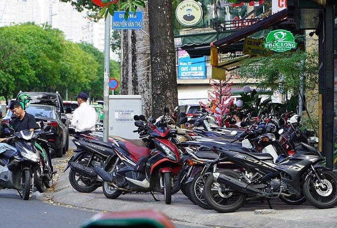 Des motos alignées sur le trottoir bloquent le passage piéton de la rue Nguyen Van Thu, 1er arrondissement. Photo : Gia Minh