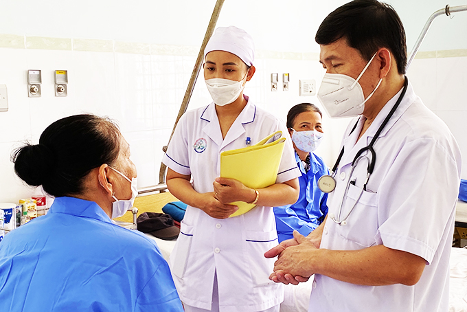 Provincial Oncology Hospital doctor discusses medical condition with inpatient.