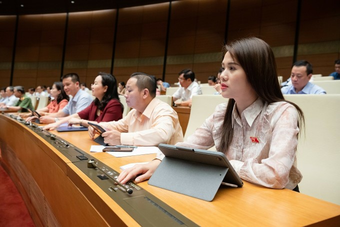 Les délégués de l'Assemblée nationale ont appuyé sur le bouton pour approuver le projet dans la salle Dien Hong. Photo : Pham Thang