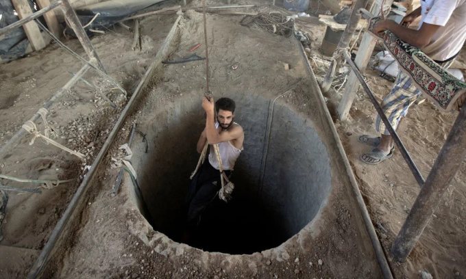 Một người dân Palestine sử dụng hệ thống hầm ngầm tại Dải Gaza. Ảnh: AFP