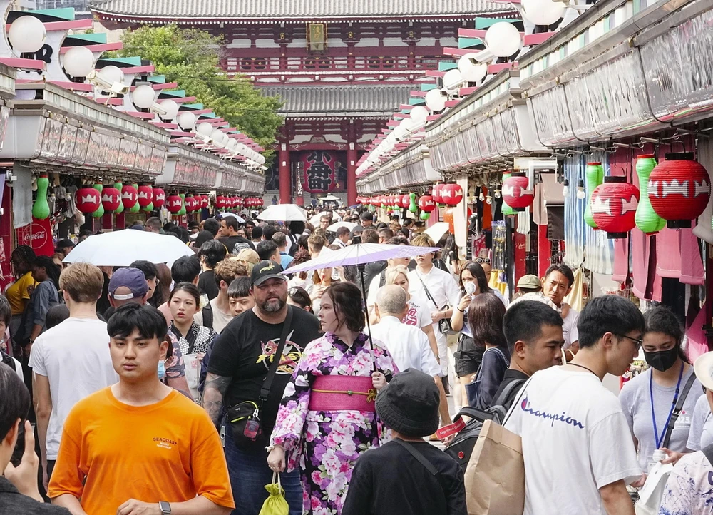 Des touristes visitent une rue commerçante du quartier d'Asakusa à Tokyo, au Japon. (Photo : Kyodo/VNA)