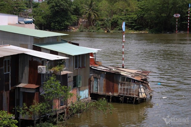 ホーチミン市の運河沿いに建てられた仮設住宅の対照的な風景（写真8）