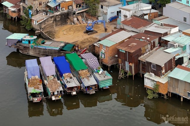 ホーチミン市の運河沿いに建てられた仮設住宅の対照的な風景、写真2