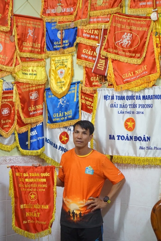 Mr. Diep and the wall with the awards he won during his time participating in athletics. Photo: Quang Huy