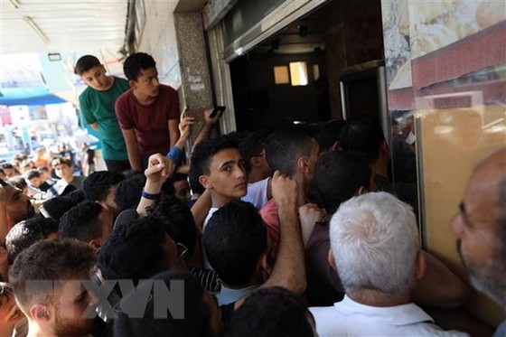 Người dân xếp hàng chờ nhận thức ăn cứu trợ tại Dải Gaza. Ảnh: TTXVN ảnh 1