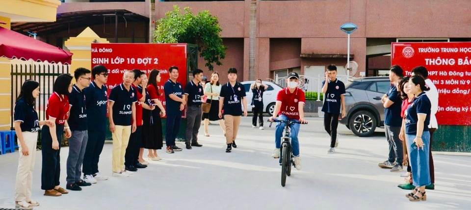 Los profesores de la escuela secundaria Ha Dong dan la bienvenida a los estudiantes en la puerta de la escuela.