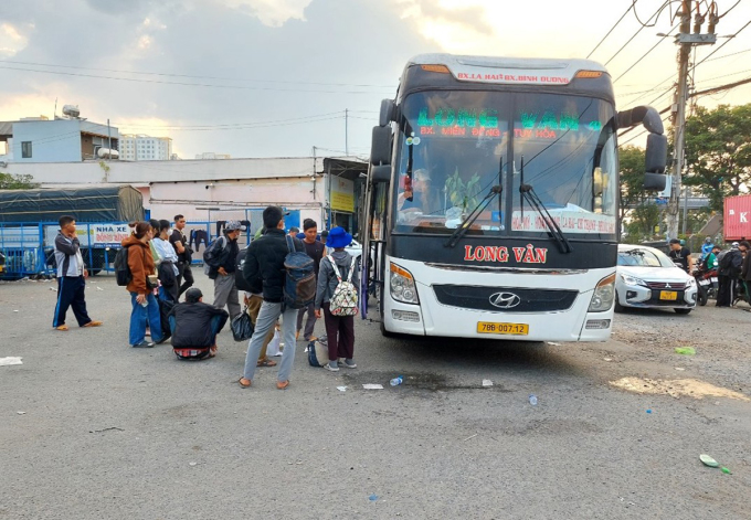 Passengers wait to get on the bus at a gas station on Highway 1, near Binh Phuoc intersection, late January 2024. Photo: Gia Minh