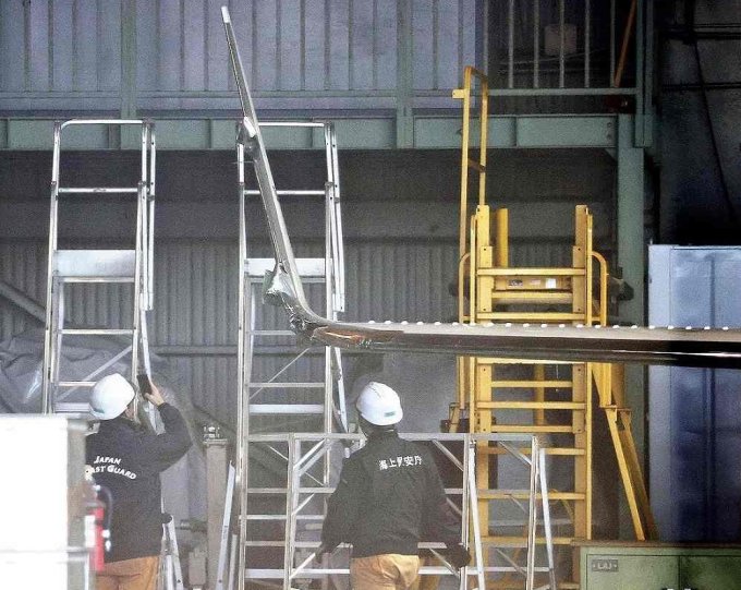 1月4日、羽田空港で衝突事故が発生した飛行機を海上保安庁の技術者が調査している。写真：読売新聞