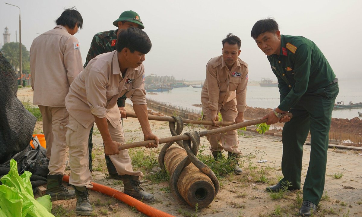 Une excavatrice touchée par une bombe sur la rive de la rivière Nhat Le