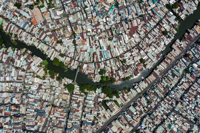 ホーチミン市の運河沿いに建てられた仮設住宅の対照的な風景写真4