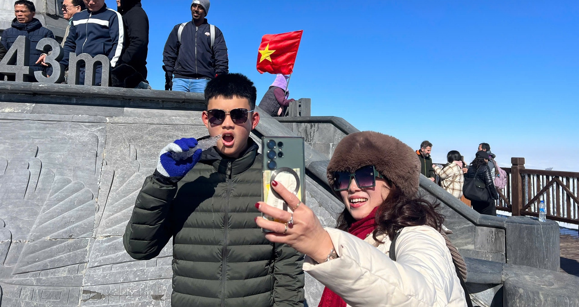 Les touristes sont enthousiasmés par la vue de la glace recouvrant le pic Fansipan, à Lao Cai