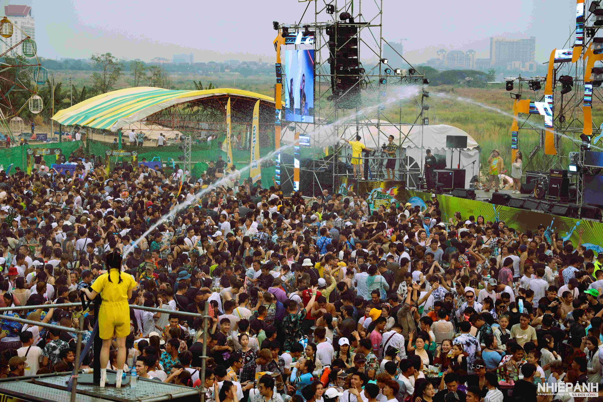 Jóvenes jugando, cantando y donando agua, recibiendo recibos rociando con dragones en el pozo de los pies.jpg