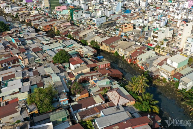 ホーチミン市の運河沿いに建てられた仮設住宅の対照的な風景写真3