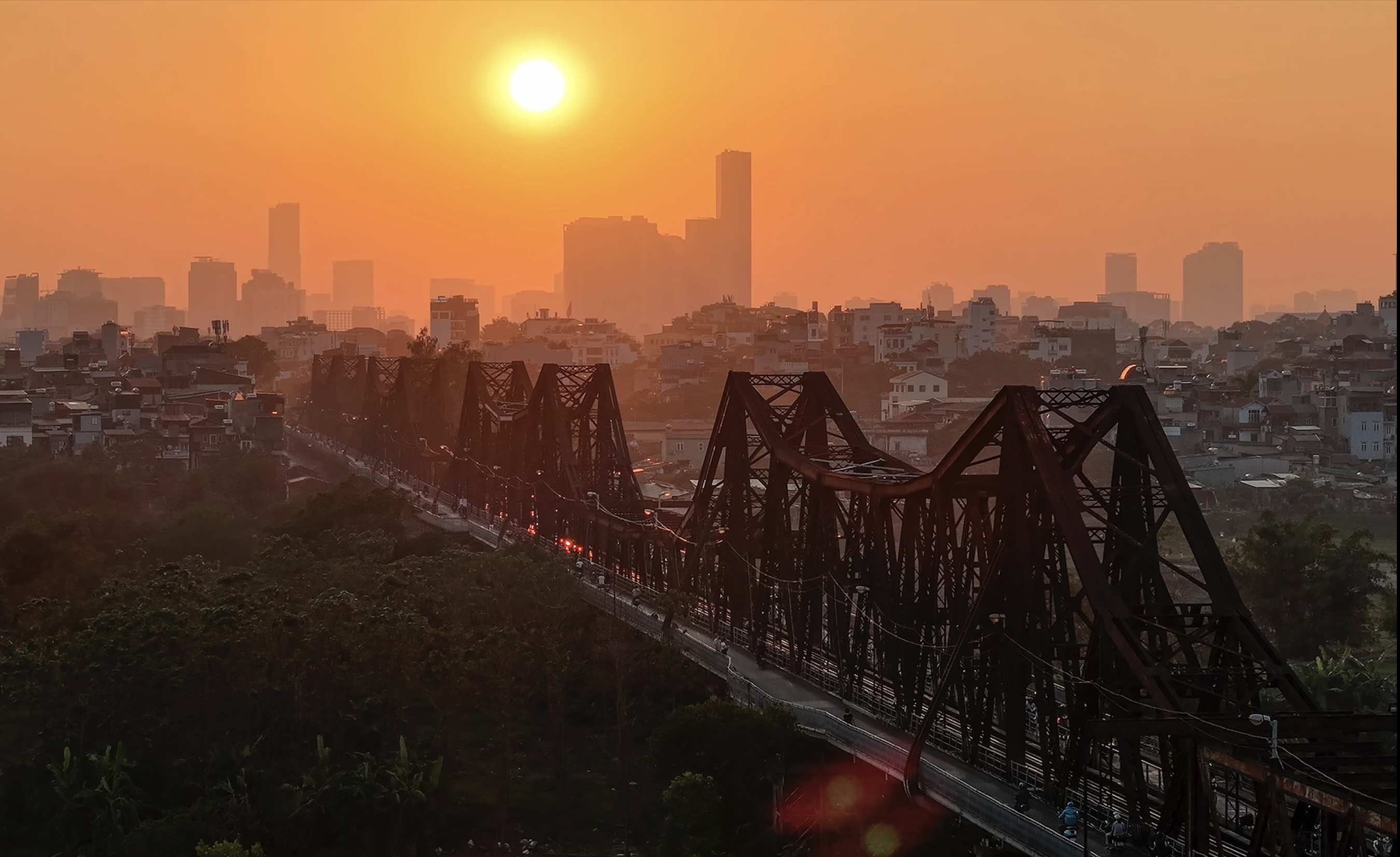 Contemple la brillante puesta de sol de finales de otoño en los dos puentes más famosos de Hanoi